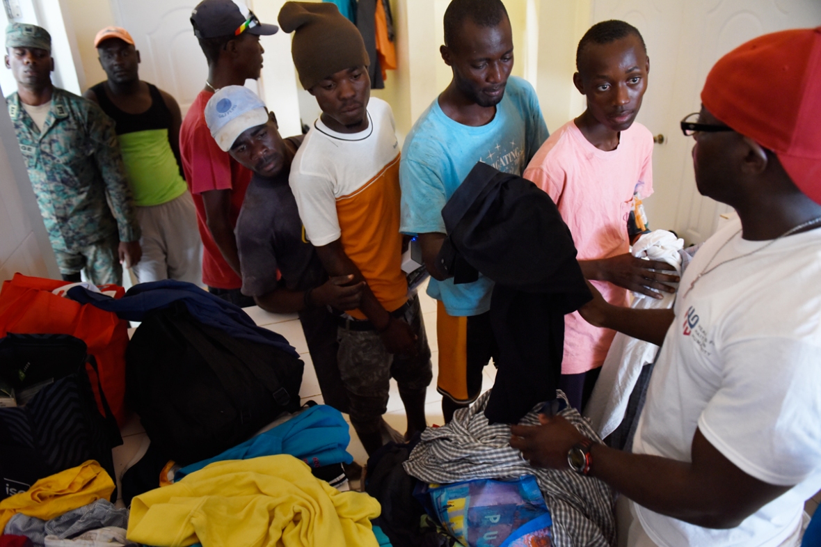 Abdias gives clothing and toiletries to young men at the shelter.
